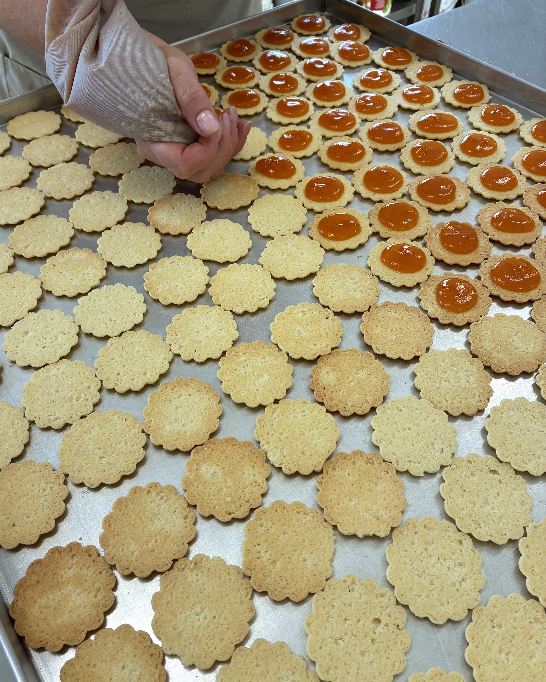 Kekse werden von Hand mit Marmelade gefüllt